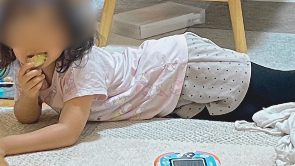 子どもが床でおやつを食べているところ